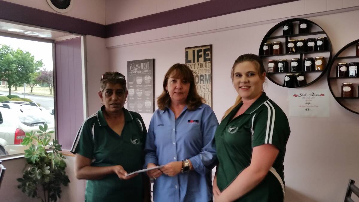 HAPPY TO HELP: Community transport co-ordinator Nadine Roach and volunteer Sashi Dean hand funds to Oberon Can Assist president Brenda Armstrong.