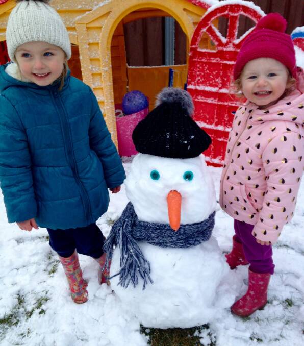 Tess and Eve Campbell built their snowman in front of the cubby house.