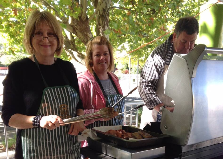 KEEPING BUSY: The Cooerwull Public P&C manning the barbecue. Photo: CAROLYN PIGGOTT