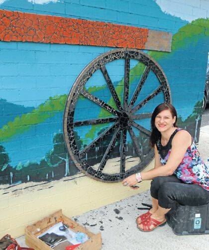 PATCH-UP: Artist Selena Seifert was back at the Oberon Common last week patching the mosaic wagons wheels after vandals removed and smashed some of the tiles.