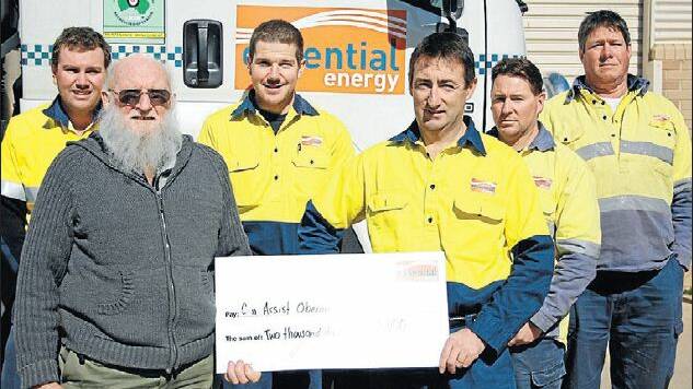 DEPOT’S CUP WIN: Can Assist Oberon president Max Sward receives a donation from Essential Energy's Oberon team.