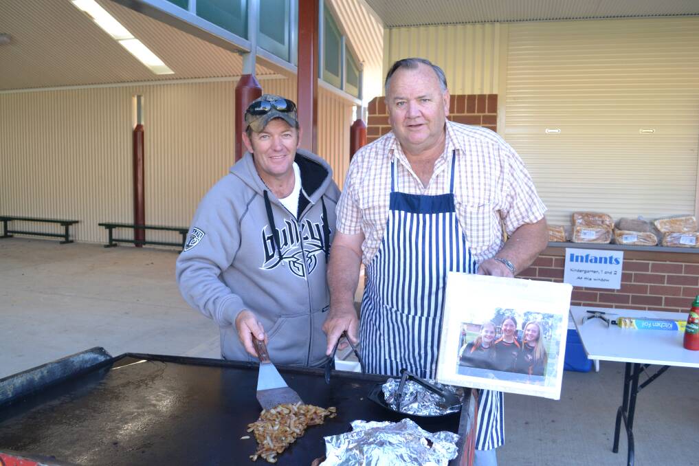 SNAG TIME: Jason Sargent and Paul Harvey are on the barbecue at Millthorpe Public School cooking up a feast for a good cause. Photo: NADINE MORTON 032815nmvote1