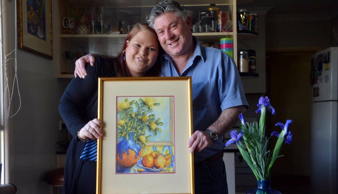 Kristal Elliott, with her dad Gary Sobey, with Christine's painting to be auctioned. PHOTO: BRENDAN MCCARTHY.