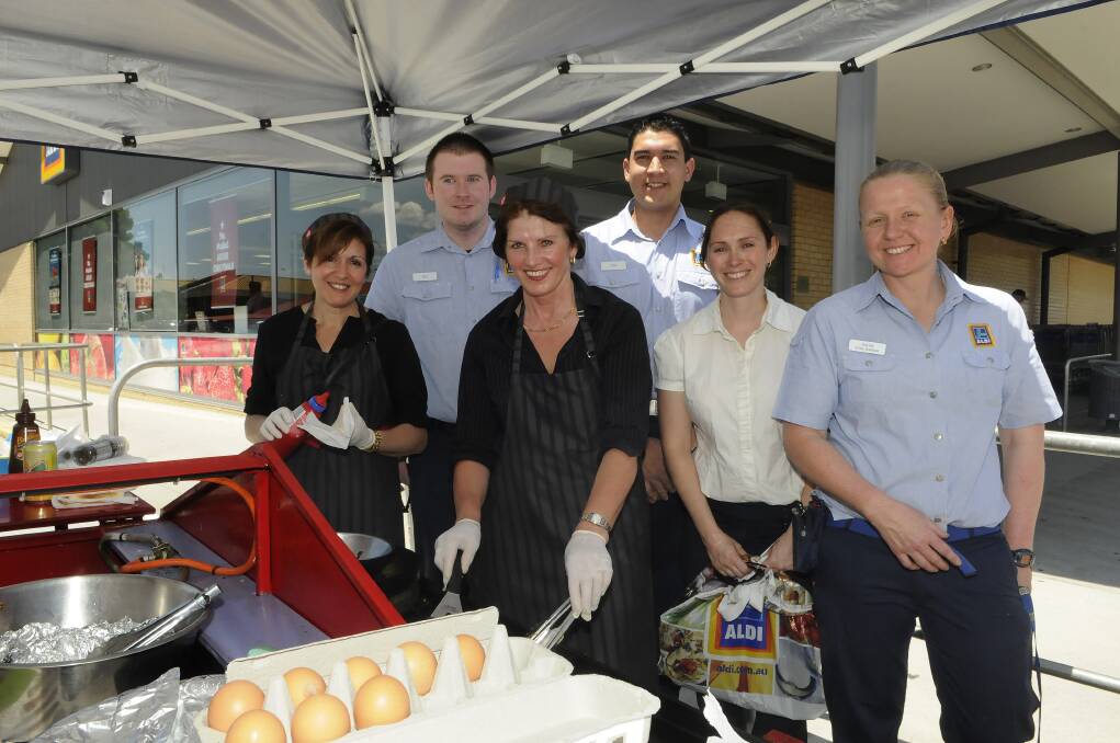 FUNDRAISER: Aldi staff members (back, from left) Ben Hope, Phil Renshaw, Renee Thatcher and Astrid Duffy with (front) barbecue chefs Lidia Tabotta and Katy Marple. 	121813paldi