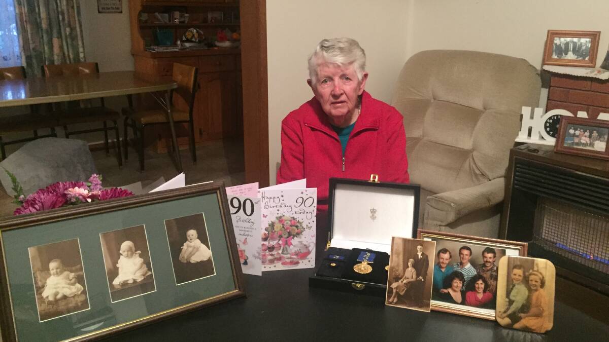 June Evans, OAM with her medal and family photos.