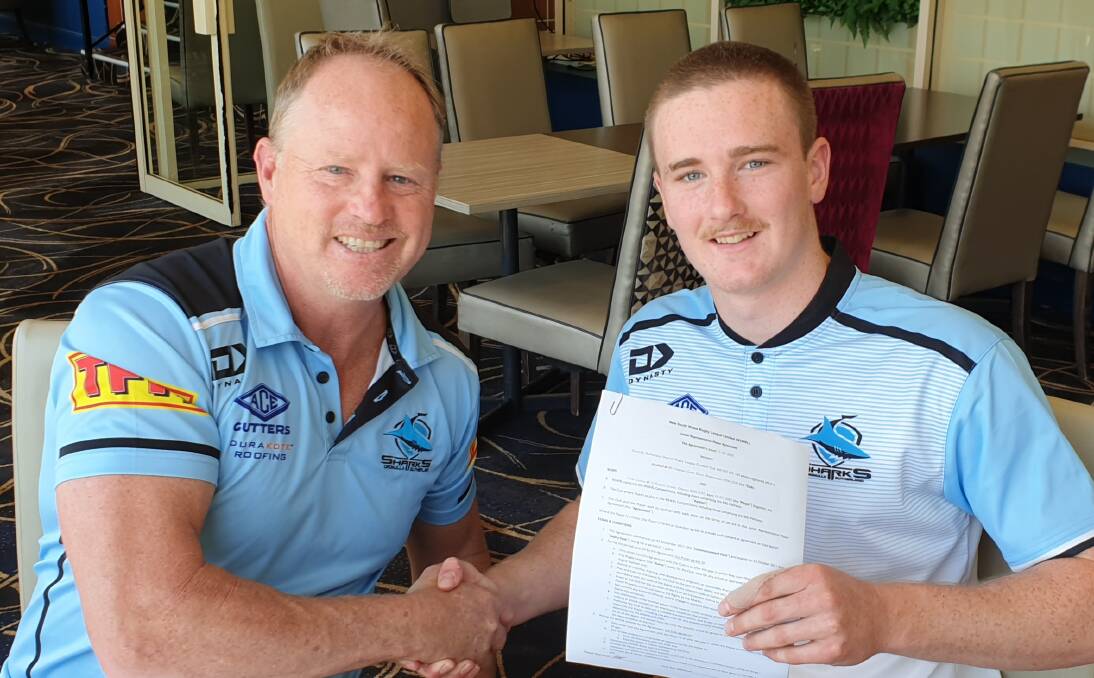 ANOTHER YEAR: Cronulla Sharks talent identification manager Glenn Brailey, with Oberon junior rugby league star Tyler Colley as he signs a new contract. Photo: SUPPLIED