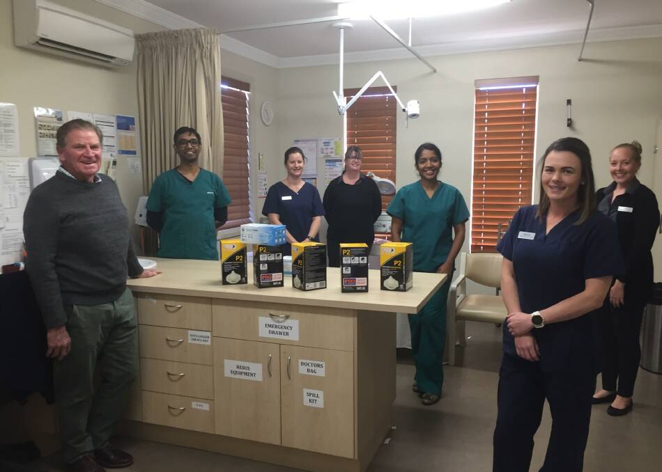 HAPPY: Ken Maddison and Dr Ayngkaran with staff at Oberon Medical Centre and donated masks and protective clothing.
