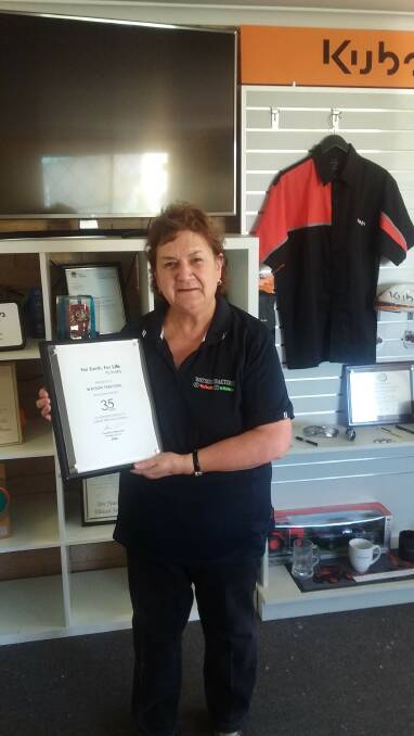 RECOGNISED: Millie Watson proudly displays her Kubota plaque for 35 years of service by Watson Tractors Bathurst.