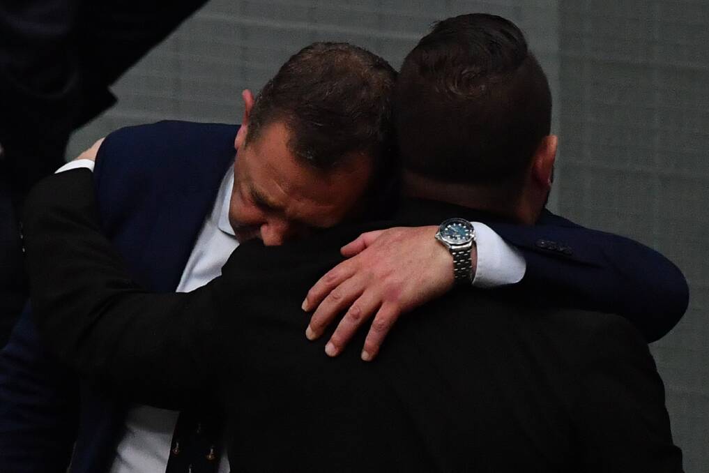 EMOTIONAL: Member for Braddon Gavin Pearce (left) receives a hug from Member for Herbert Phillip Thompson following debate on a royal commission into Veteran Suicides. Picture: Getty Images.