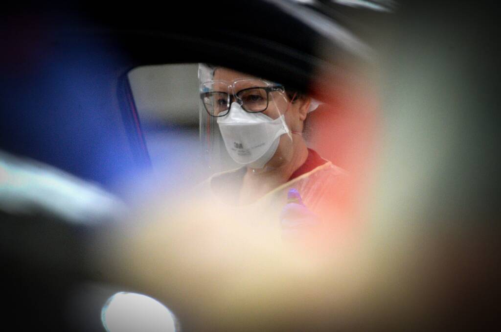 A COVID-19 tester assesses someone sitting in a car at a Bendigo drive-through clinic. Picture: DARREN HOWE