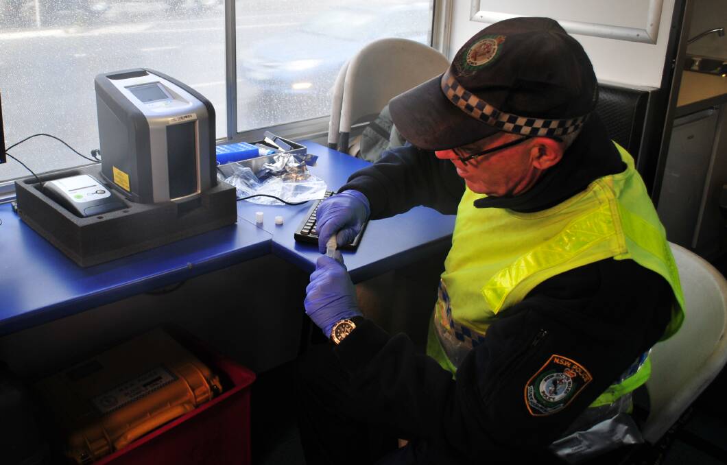 TESTING: Senior Constable John Hagan, from Traffic and Highway Patrol, doing a drug test inside the drug bus.