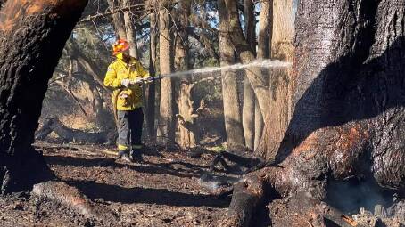 A Rural Fire Service member extinguishing a recent grass fire at on Sofala Road, near Wiagdon Hill. Photo: EGLINTON RFS