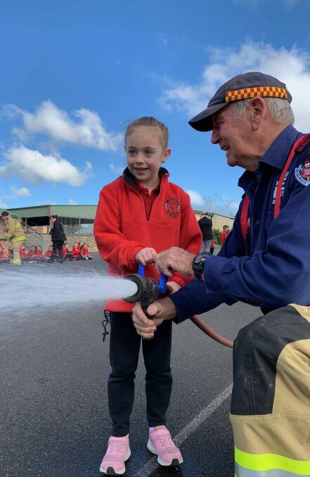 FUN: Oberon Fire and Rescue member Peter Ryan shows an Oberon Public School student how to use the hose.