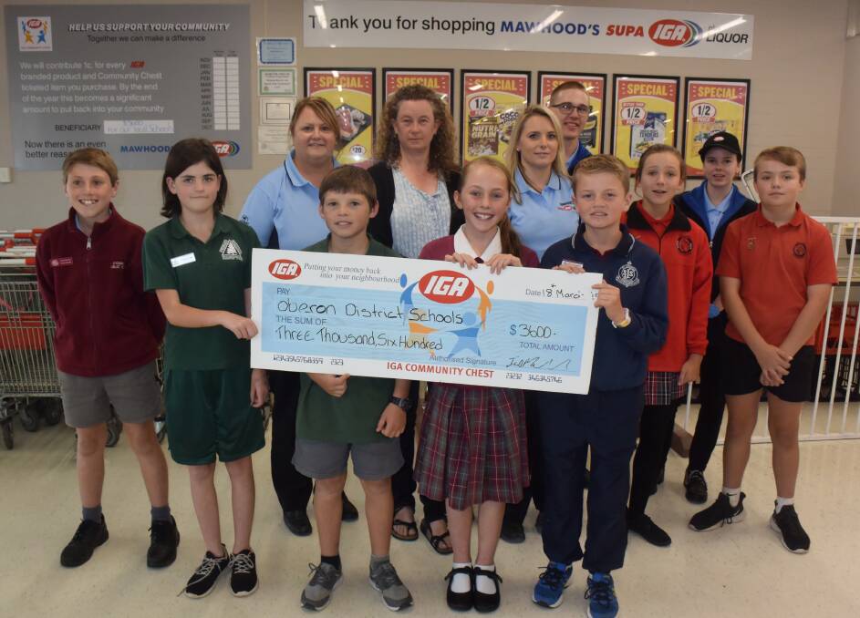 DONATIONS: Mawhood Brothers Supa IGA employees Karen Harvey and Mel Danslow present local schools with Community Chest funds.