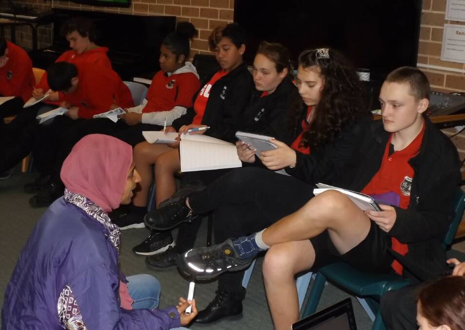 LEARNING: Manal Younus works with Oberon High School students as they focus on their own piece of writing during a workshop last week.