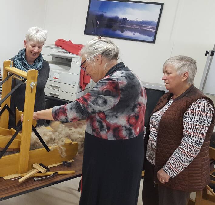 TOGETHER: FFF and Y (Fleece, Fibre, Felt and Yarn) members Sue, Judith and Lynne using a fleece picker, preparing wool for spinning.
