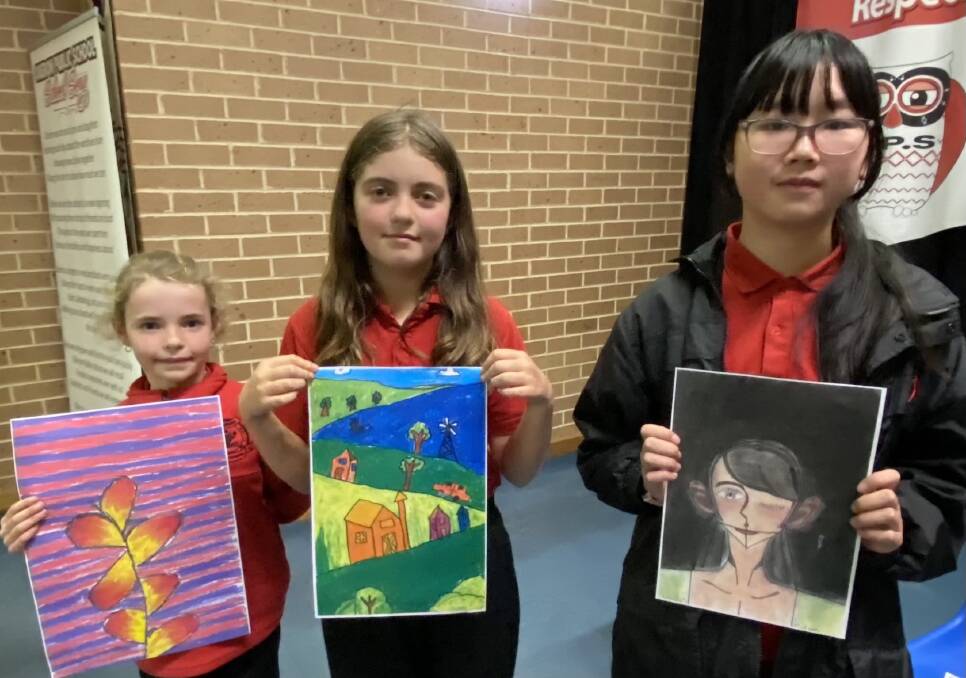 ART AT HEART: Oberon Public School students Lexi Booth, Savannah Saville and Celeste Tan with their artwork.