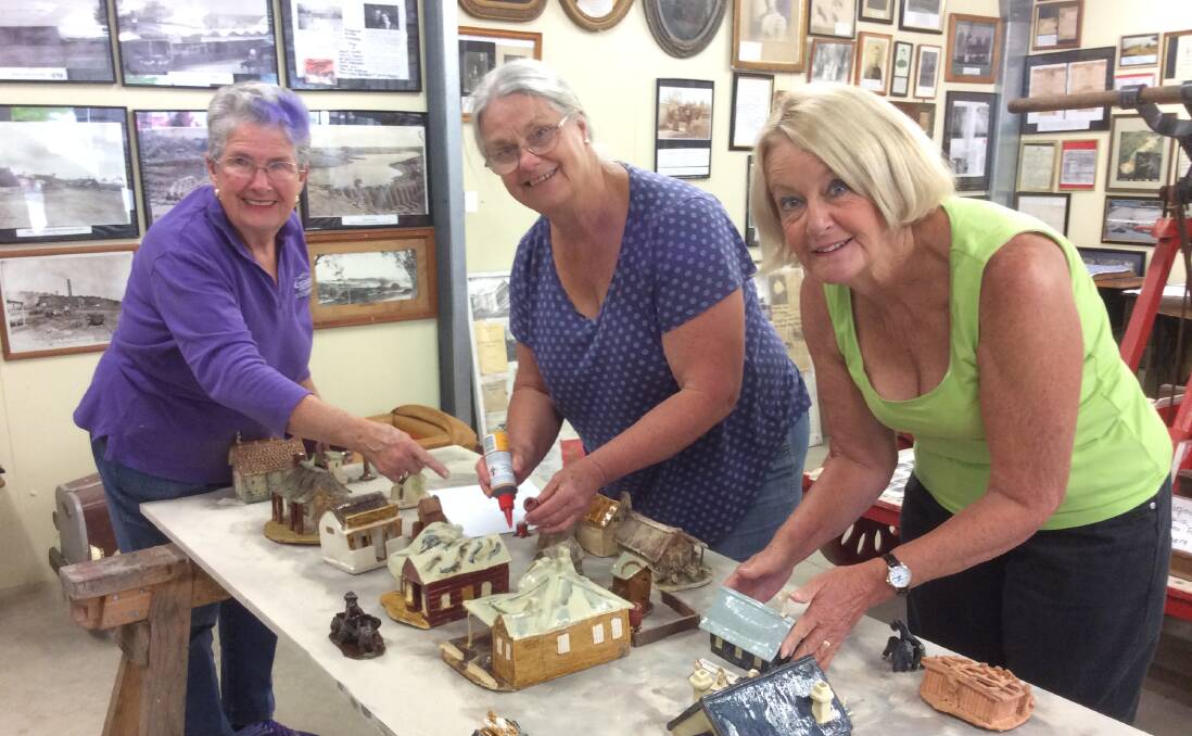 WORKERS: Volunteers Brenda Lyon, Sue Roberts and Pam Dellow restoring the pottery model of Oberon township in the 1930s.