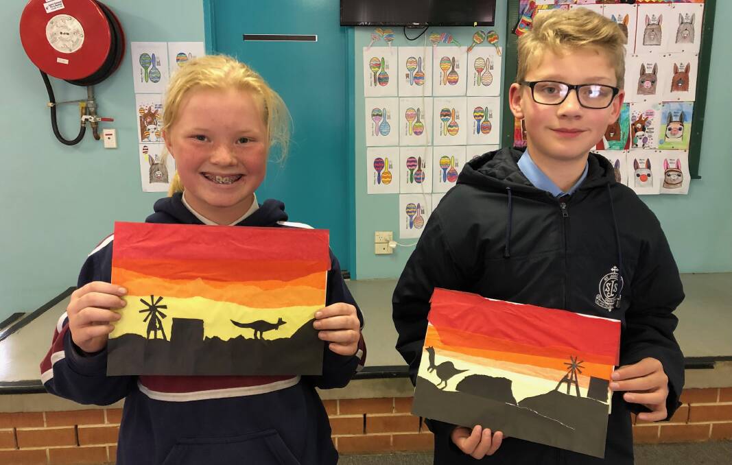 SMILE: St Joseph's students Cady Coyle and Anthony Scorgie with their Australian sunset paintings.