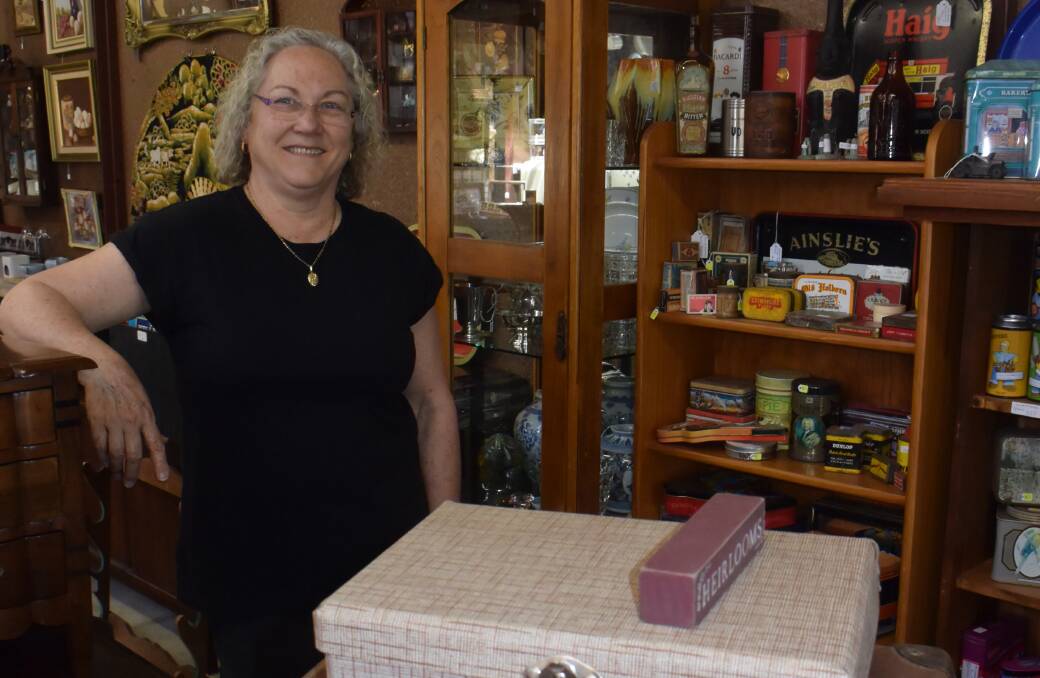 LOTS OF GOODIES: Hazelgrove Cottage owner Kaye Dureau next to her collection of old tins and suitcases.