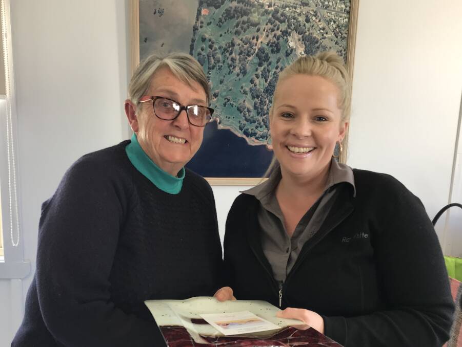SMILES: Joan Sullivan, winner of the open day Division 3 stableford competition, accepting the prize from Ray White Emms Mooney representative Jess Foley.
