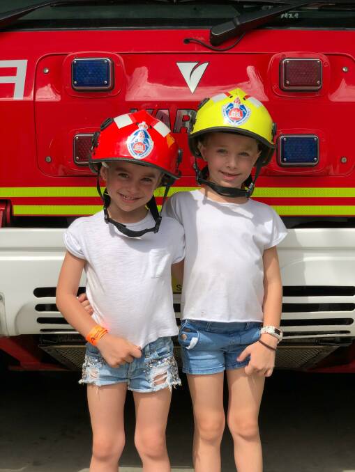 BIG SMILES: Two potential fire fighters learning about the fire truck, equipment and fire safety in the home.