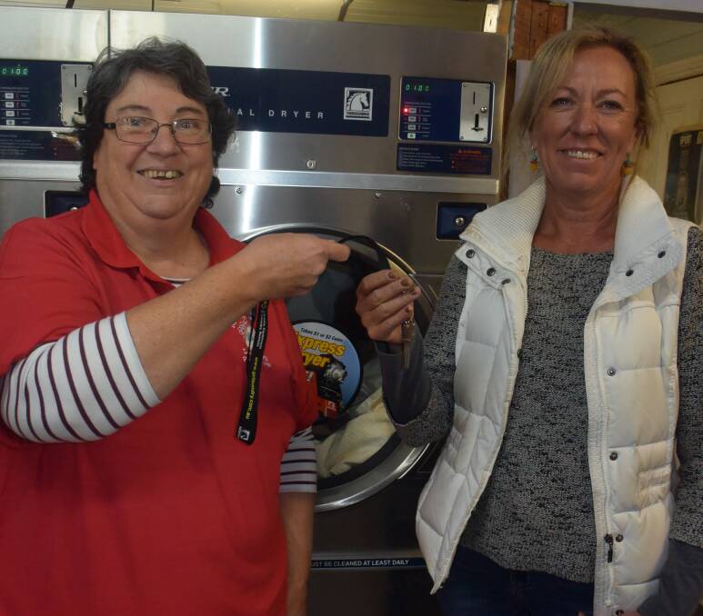 HAPPY: Roseville Laundry owner Jules Hanlon hands the keys over to new owner Vicki Walsh.