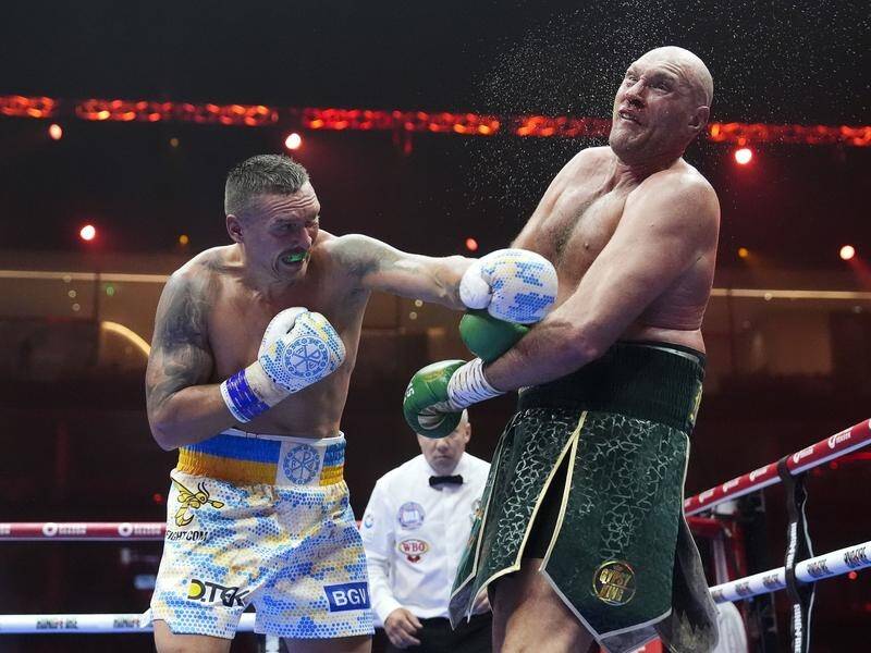 Oleksandr Usyk (l) rattles Tyson Fury on his way to becoming undisputed heavyweight world champion. (AP PHOTO)