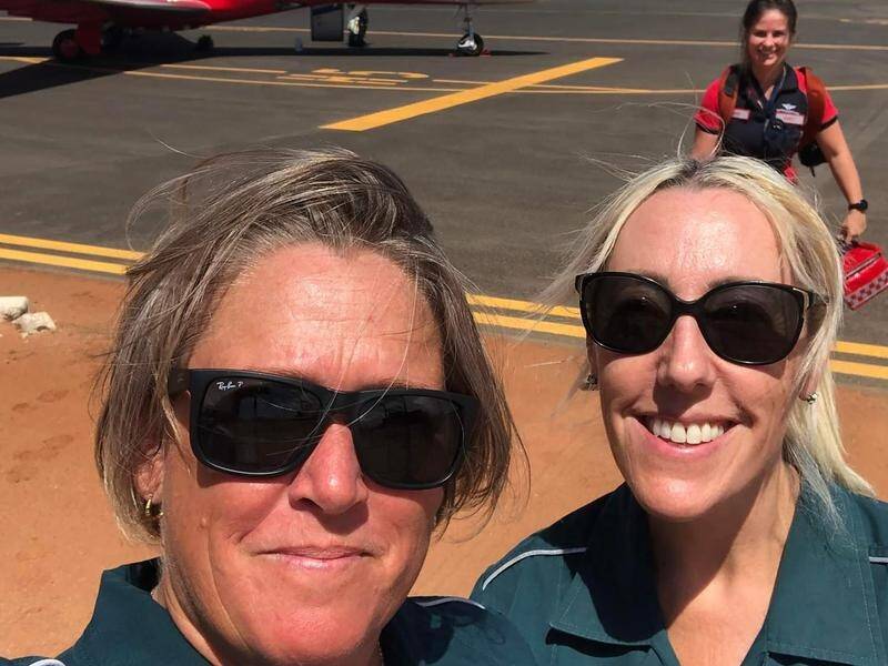 Medics Hayley Brett (left) and Tanya Millgate on Onslow airport's tarmac the day it hit 50.7C.