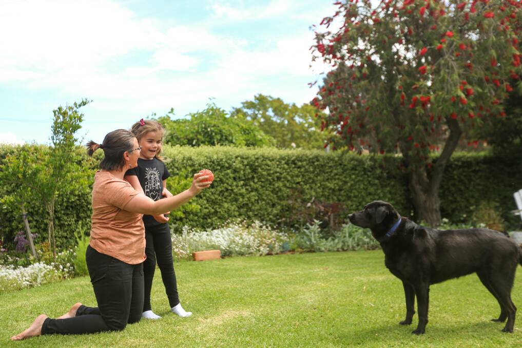 LOVE: Jane Kohne, 6, with mum Jill and dogs, Suzie and Alli watch on. Picture: JAMES WILTSHIRE